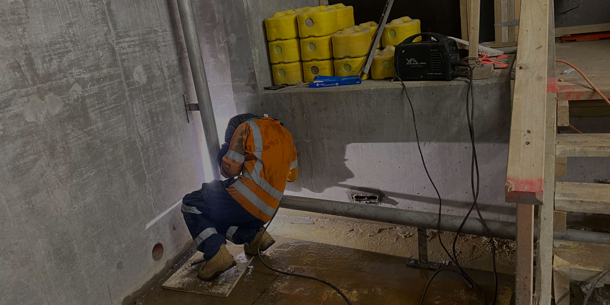 Professional welder performing MIG welding on heavy machinery